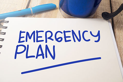 Emergency plan written in blue on a notepad